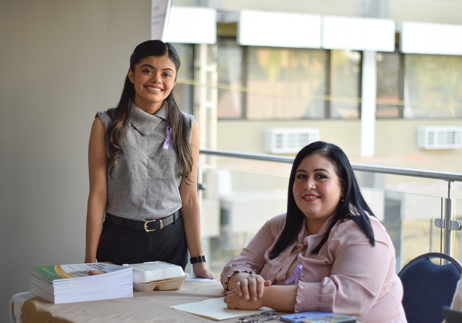 Dos colaboradoras sonriendo en una mesa de atención